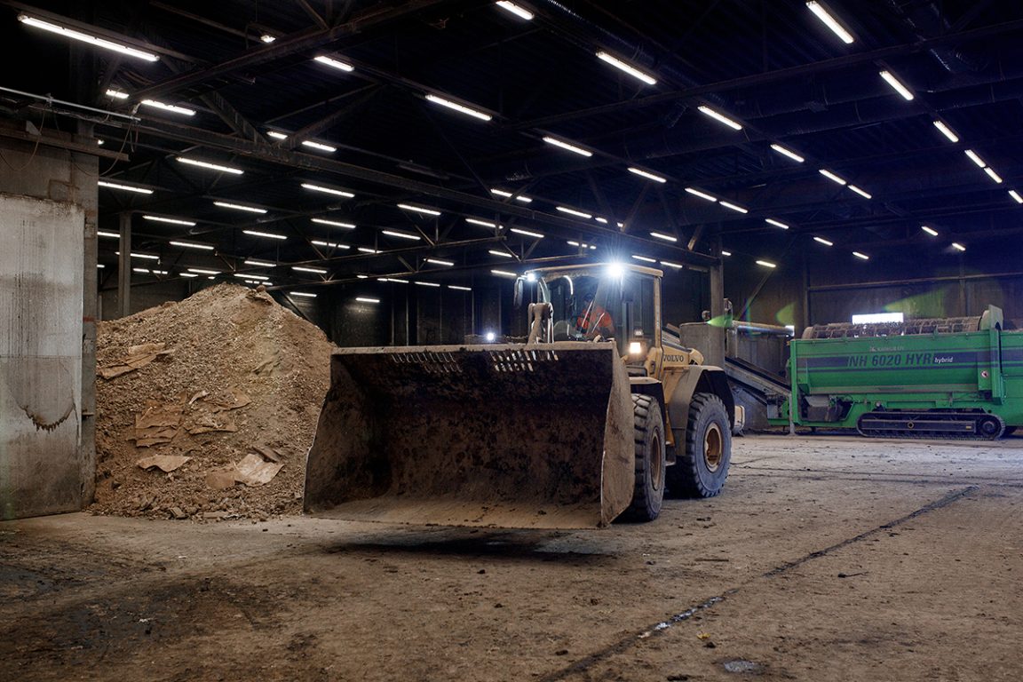 Tractor with shovel in a composting factory